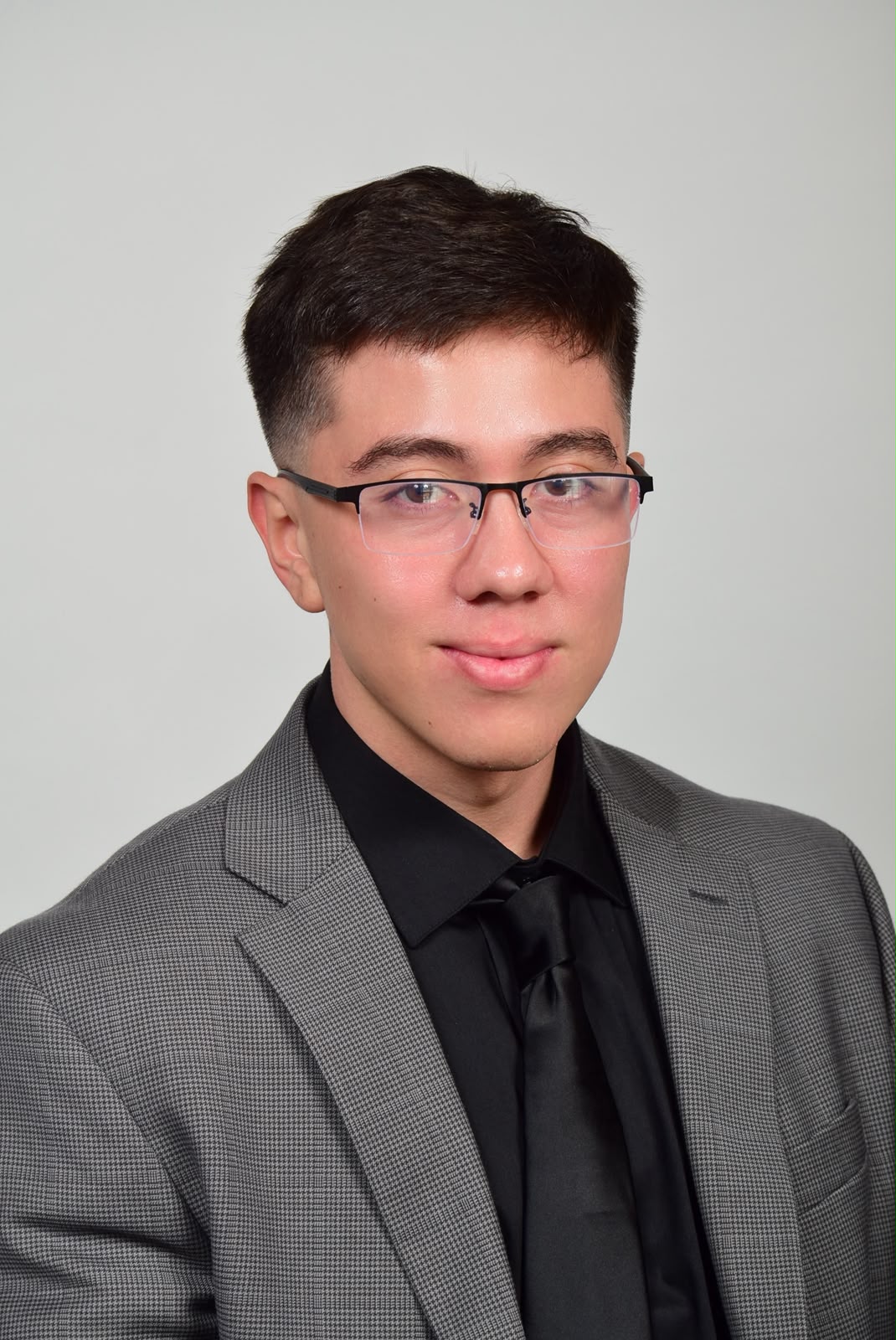 Freddy Flores wearing glasses and a gray suit